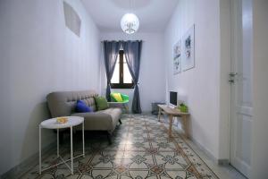 un soggiorno con divano e tavolo di De Nobili's Apartments a Trapani
