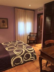 a bedroom with a bed and a table and a window at Hotel Baviera in Linares