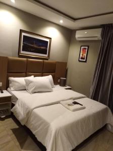 a hotel room with two beds with white sheets at Blackwood Hotels in Ikeja