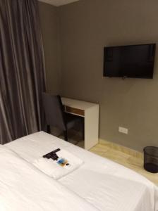 een hotelkamer met een bed en een tv aan de muur bij Blackwood Hotels in Ikeja