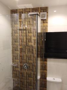 uma casa de banho com uma cabina de duche em vidro e um WC. em Blackwood Hotels em Ikeja