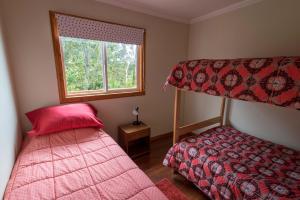 1 dormitorio con 2 camas y ventana en Casa Arrayan Alto, en Valdivia