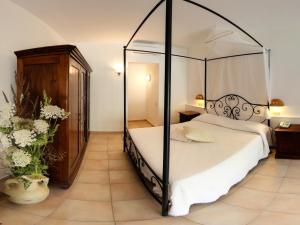 a bedroom with a four poster bed with a canopy at Hotel Spartivento in Chia