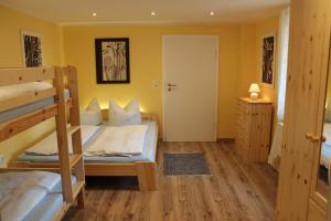 a bedroom with two bunk beds and a door at Ferienwohnung Troge in Kurort Gohrisch