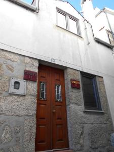 un edificio con una puerta de madera delante de él en Coreto Apartments, en Sabugueiro