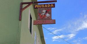 a sign on the side of a building with a slo horse at Pousada São Jorge in São Thomé das Letras