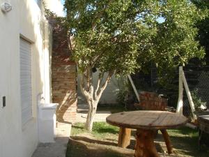 una mesa de madera sentada junto a un árbol en Glaniad Apartments, en Puerto Madryn