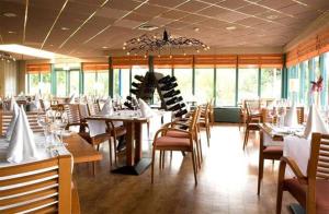 a dining room with tables and chairs and windows at Ameland Rentals Hollum in Hollum