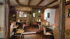 a restaurant with tables and chairs and a brick wall at Gästehaus By George in Stolberg