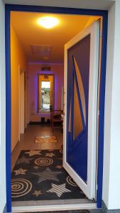 a hallway with a blue door and a carpet at Haus Kliffblick in Glowe