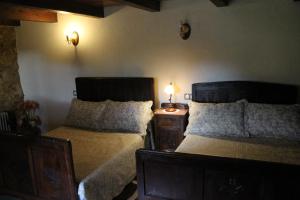 a bedroom with two beds and two lights on the wall at Casiña de Campo in Ferreiros