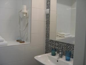 a bathroom with a sink and a phone on the wall at Apartment Be My Guest in Zagreb