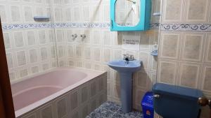 a bathroom with a pink tub and a sink at Alojamiento Rural Bellavista in Filandia