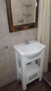 ein weißes Waschbecken in einem Badezimmer mit einem Spiegel in der Unterkunft Verdeymar in Santa Clara del Mar