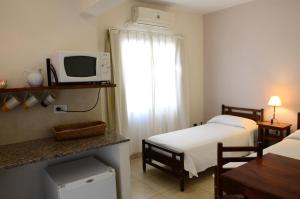 um quarto de hotel com duas camas e um micro-ondas em Hotel Portal del Río em La Paz