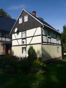 una casa blanca y negra con techo negro en Adventure House (Abenteuerferienhaus), en Rechenberg-Bienenmühle