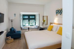 杜布羅夫尼克的住宿－Room St. Jacob Dubrovnik，卧室配有白色的床和蓝色椅子