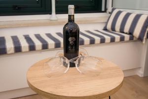 una botella de vino sentada en una mesa con copas en Room St. Jacob Dubrovnik en Dubrovnik