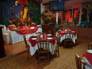 a dining room with two tables with red tablecloths at Casa Lima B&B in San José