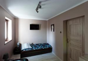 グダニスクにあるMieszkanie 3 pokojowe w Śródmieściuのドアとテレビ付きのベッドが備わる客室です。