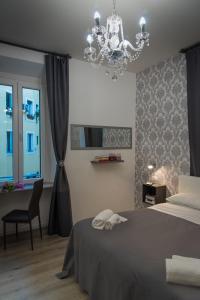 Schlafzimmer mit einem Bett und einem Kronleuchter in der Unterkunft Inside Roma Rooms in Rom