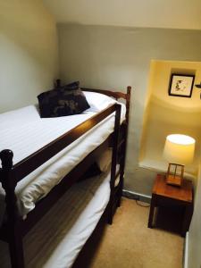 a bedroom with a bed and a table with a lamp at Mason's Arms in Bowland Bridge