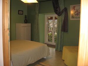 Chez Robert et Catherine في Dompierre-sur-Mont: غرفة نوم بجدران خضراء وسرير ونافذة