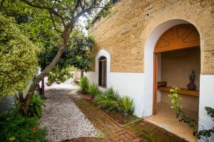 a building with an archway next to a walkway at Casa María Guest House in Santa Cruz Etla