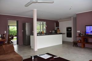 a kitchen and living room with purple walls and a counter at Bas de villa Noumea in Noumea