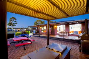 
a patio area with chairs, tables, and umbrellas at BIG4 Traralgon Park Lane Holiday Park in Traralgon
