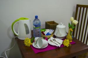 a table with a coffee maker and a jug and a cup at girilena resort in Dambulla
