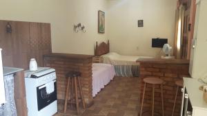 a kitchen with a stove and a room with a bed at Casas do Adriano in Conceição da Ibitipoca