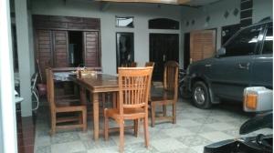 ein Esszimmer mit einem Tisch und Stühlen sowie einem Auto in der Unterkunft Sri Dewi Homestay in Ranuyoso