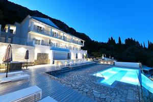 una villa con piscina di fronte a un edificio di Platakia Blu a Paleokastritsa