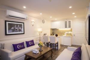 a living room with a couch and a table at Saigon By Night Luxury Hotel in Ho Chi Minh City