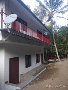 a building with a red roof and a tree at Sunleo Spice Villas & Homestay in Munnar