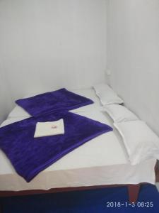 a bed with a blue and white blanket and pillows at Sunleo Spice Villas & Homestay in Munnar