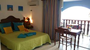 1 dormitorio con cama, mesa y escritorio en Turquoise Caritan, en Sainte-Anne