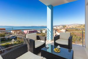 einen Balkon mit Stühlen und einem Tisch mit Aussicht in der Unterkunft Villa Mermaid Your Croatian Haven with Luxury Pool and Scenic Views in Podstrana