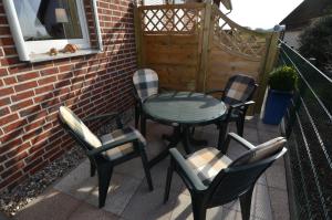 a patio with four chairs and a table and chairs at Ferienhaus Lobbe - Wohnung 04 mit Terrasse strandnah in Lobbe