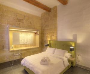 a bedroom with a bed with two towels on it at Le Margherite in Kalkara