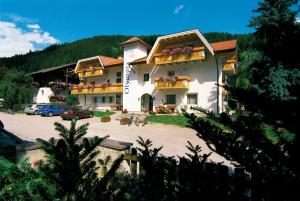 a large building with a parking lot in front of it at Hotel Olympia in Sarntal
