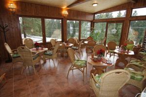 a dining room with tables and chairs and windows at Chata Javorina in Javorník