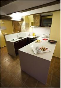 a kitchen with a white counter top with food on it at Apartamentos Doña Candida in Valderrobres