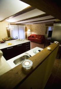 a kitchen with a sink and a living room at Apartamentos Doña Candida in Valderrobres