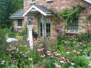 a garden in front of a brick house with flowers at Annie's cottage in Kurrajong