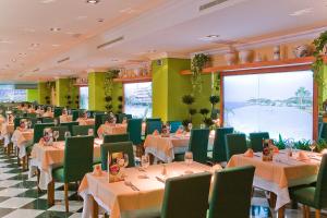 uma sala de jantar com mesas e cadeiras verdes em Playamarina na Isla Canela