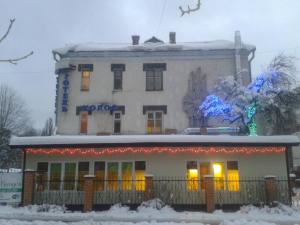 キーウにあるKolos Hotel Obolonの雪中のクリスマス灯が付いた建物