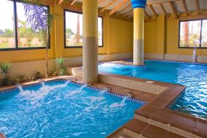 a pool in a hotel with columns and a swimming pool at Playa Marina Spa Hotel - Luxury in Isla Canela