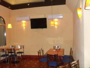 a dining room with tables and chairs and a flat screen tv at Hotel San Jose in M&eacute;rida
